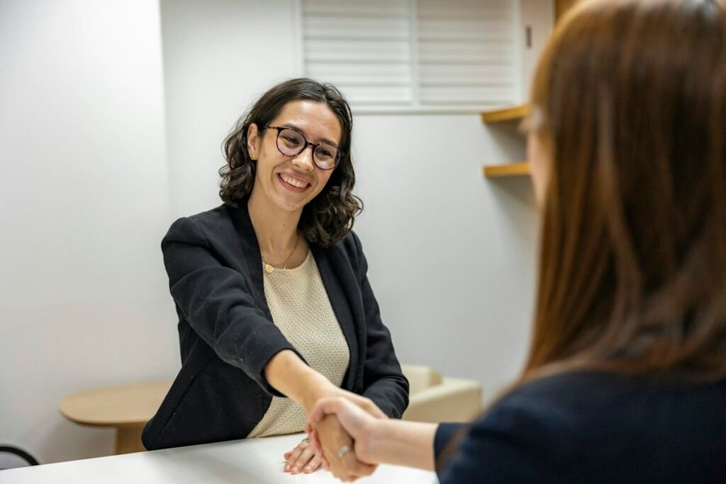 Candidata y reclutador estrechando las manos después de una entrevista de trabajo