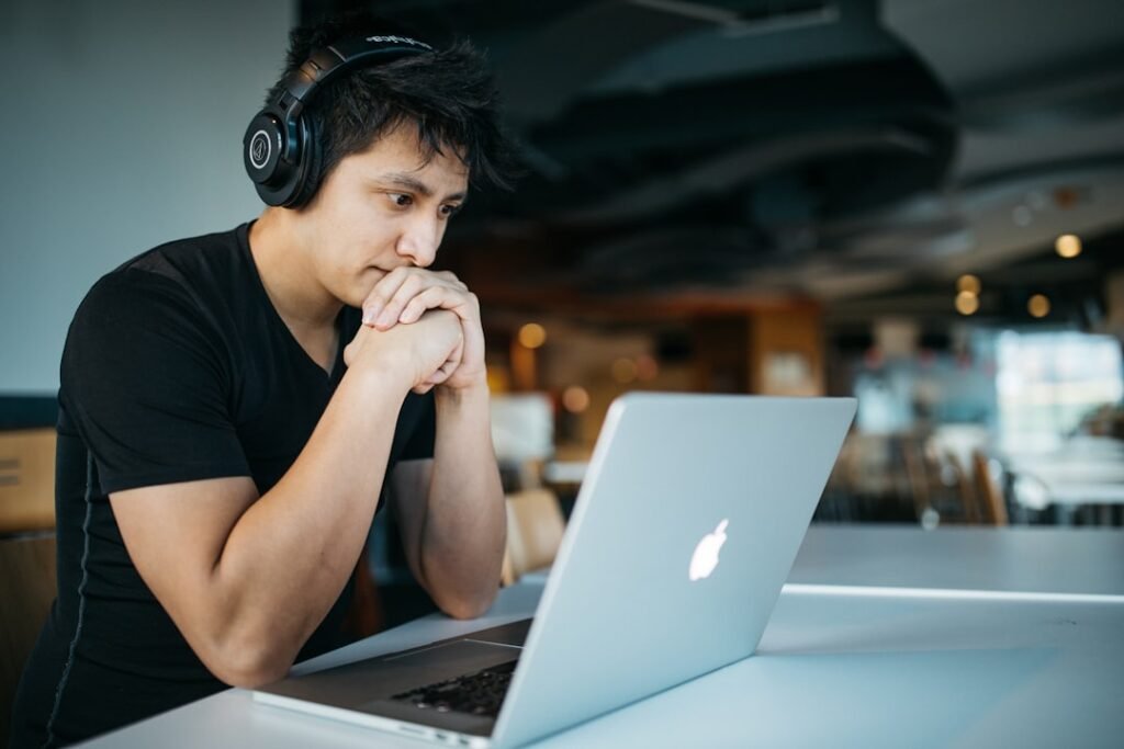 Estudiante utilizando una computadora portátil y audífonos para estudiar e investigar